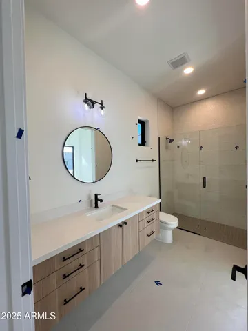 a bathroom with a double vanity sink mirror and toilet