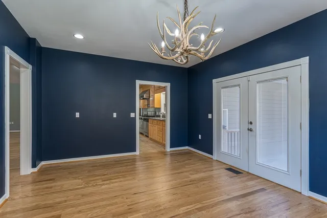 wooden floor in an empty room with a chandelier