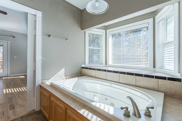 a view of a livingroom with a fireplace wooden floor and a ceiling fan