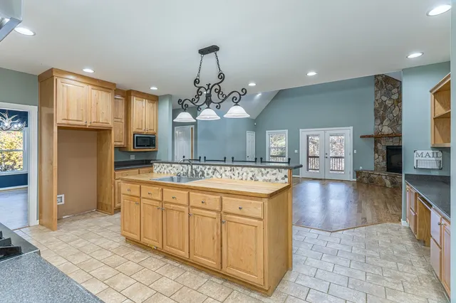 a large kitchen with kitchen island a chandelier and living room view