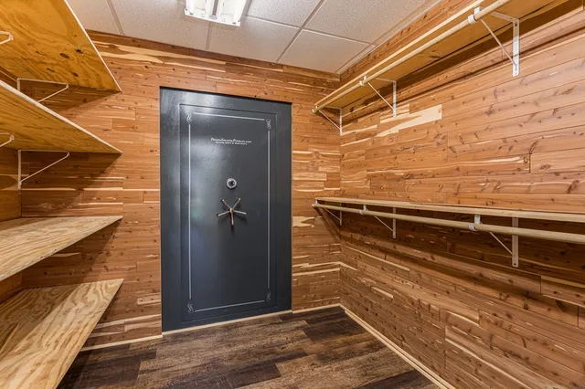 a view of a white house next to a yard with large trees