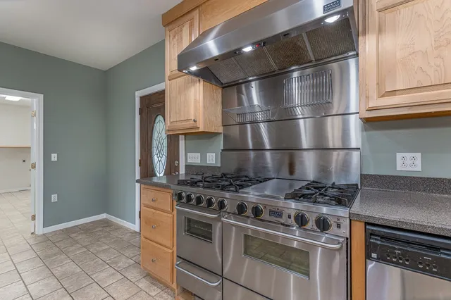 a kitchen with granite countertop a stove and a refrigerator