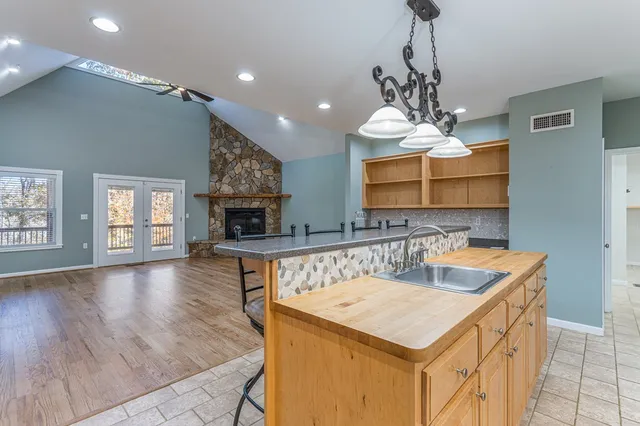 a kitchen with a stove a sink a chandelier and a refrigerator