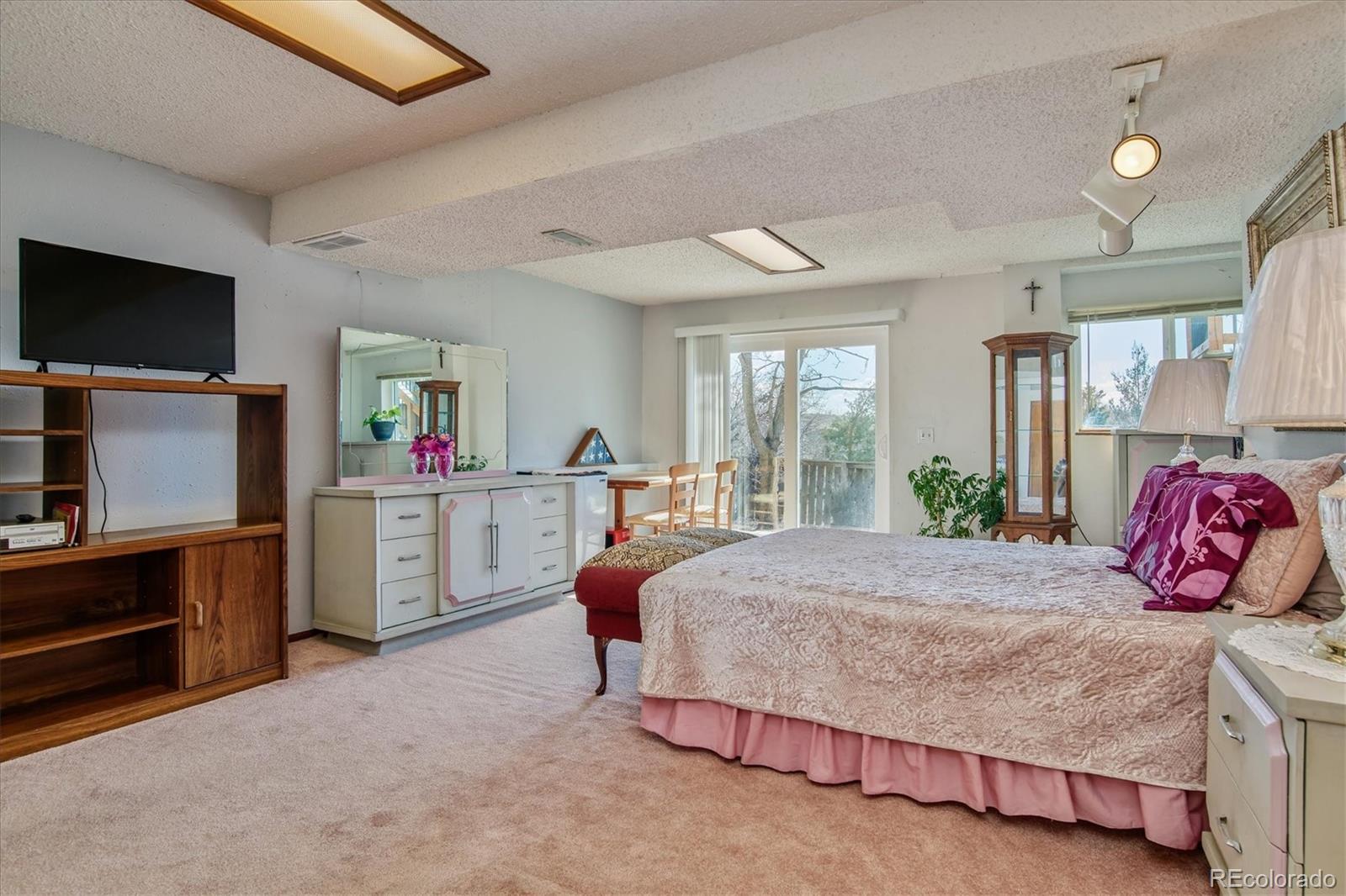 462 Northridge Road Highlands Ranch, CO 80126 - Photo 26 of 36 a bedroom with a bed and flat screen tv