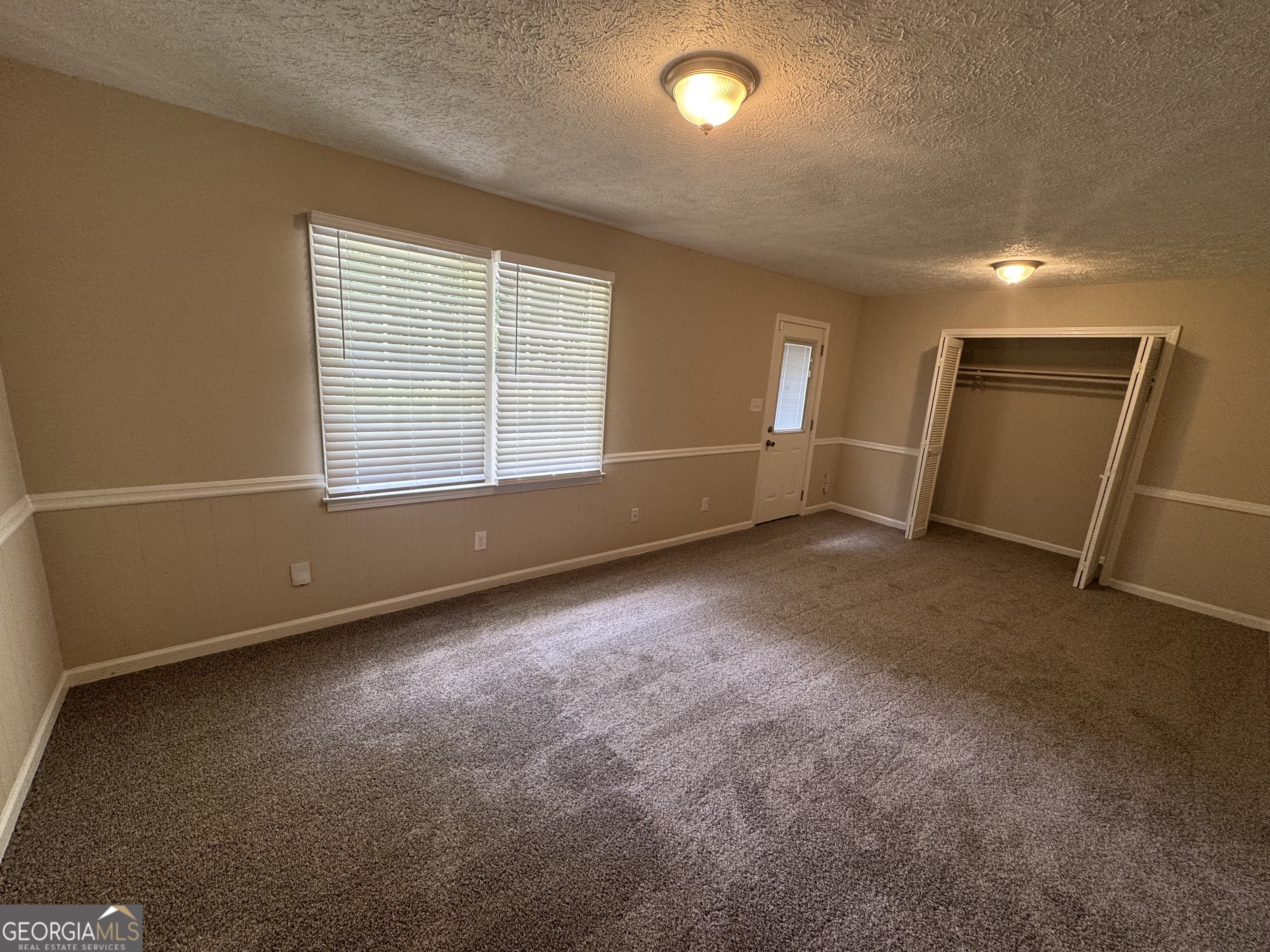 8347 Union Grove Road Lithonia, GA 30058 - Photo 6 of 9 an empty room with a empty space and windows