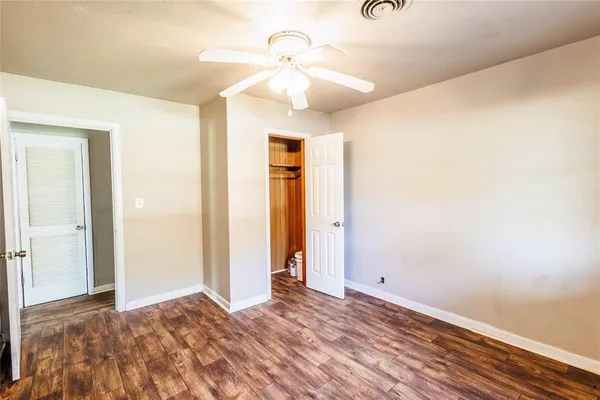 a view of a livingroom with wooden floor and a ceiling fan
