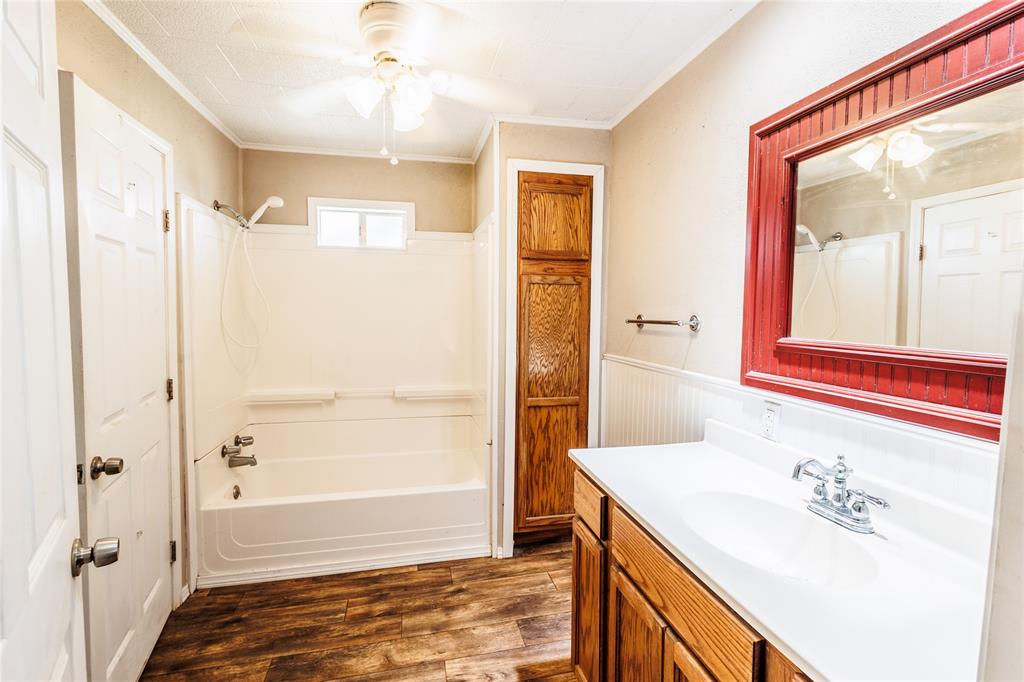 202 North Sycamore Malone, TX 76660 - Photo 13 of 22 a bathroom with a tub sink and mirror