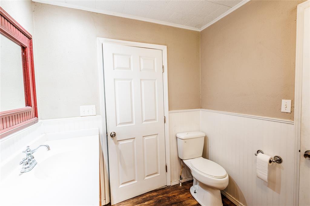 202 North Sycamore Malone, TX 76660 - Photo 15 of 22 a white toilet sitting next to a bathroom sink