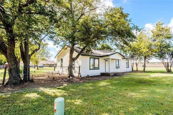 a front view of a house with a yard and trees