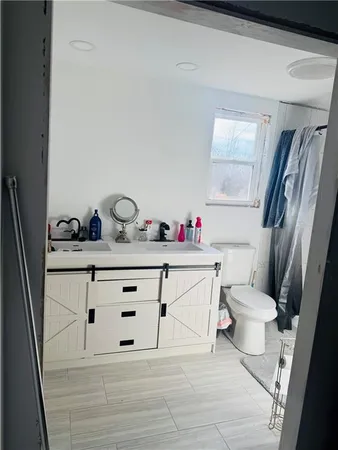 a bathroom with a sink vanity mirror and toilet