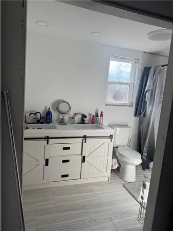 a bathroom with a sink vanity mirror and toilet
