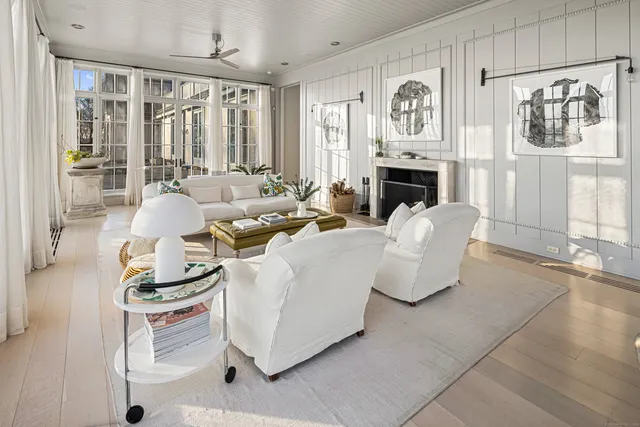 a living room with furniture a fireplace and a large window