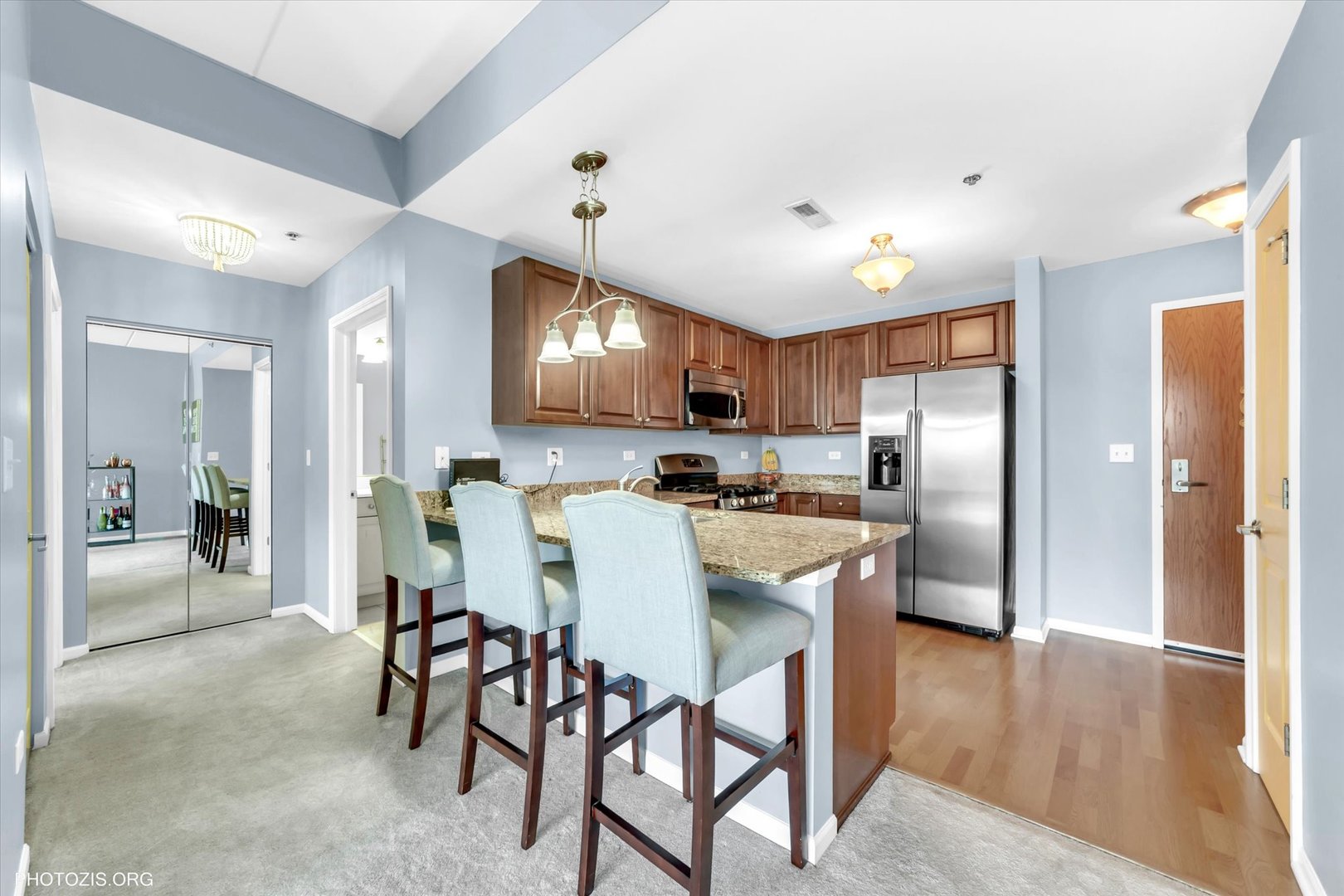 1199 East Port Clinton Road, Unit 201 Vernon Hills, IL 60061 - Photo 5 of 19 a kitchen with stainless steel appliances kitchen island granite countertop a refrigerator and a stove top oven
