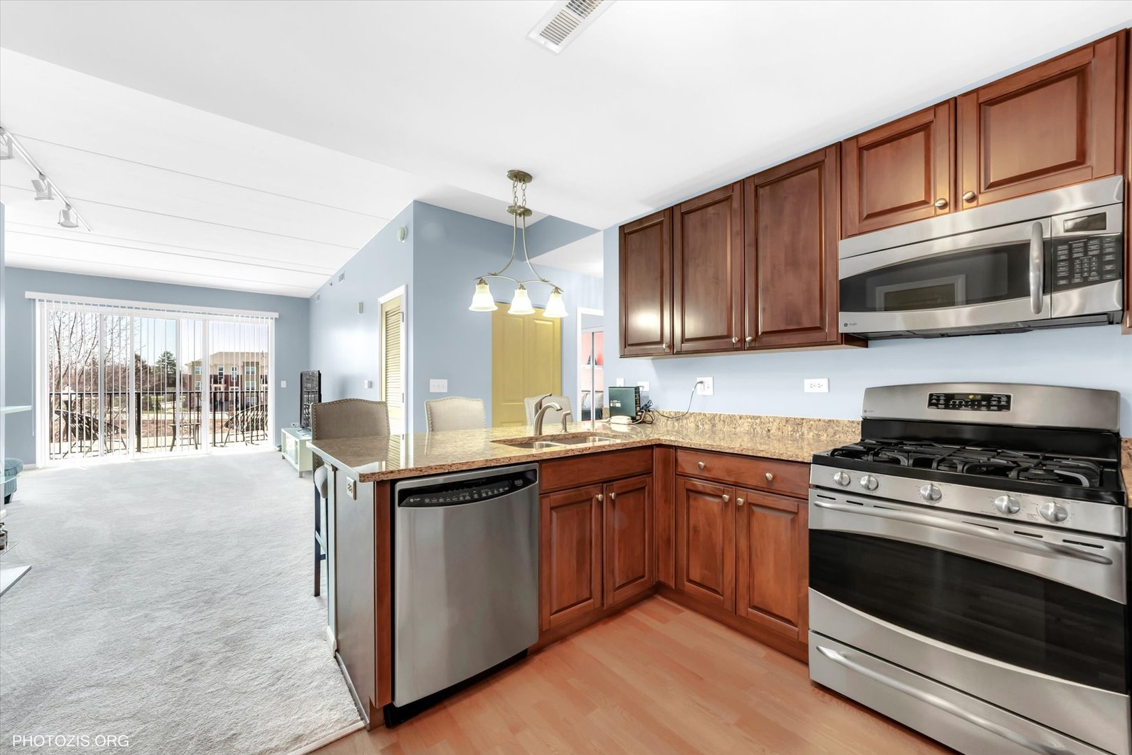 1199 East Port Clinton Road, Unit 201 Vernon Hills, IL 60061 - Photo 7 of 19 a kitchen with stainless steel appliances granite countertop wooden cabinets stove top oven and sink