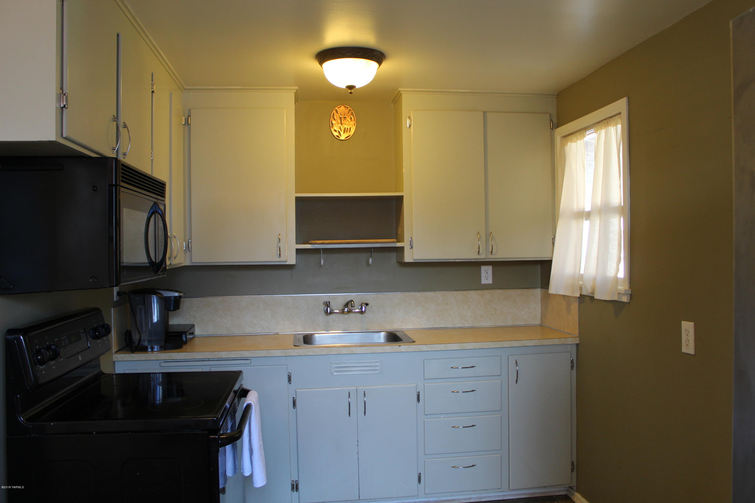 511 West 3rd Avenue Toppenish, WA 98948 - Photo 10 of 18 a kitchen with white cabinets and a sink