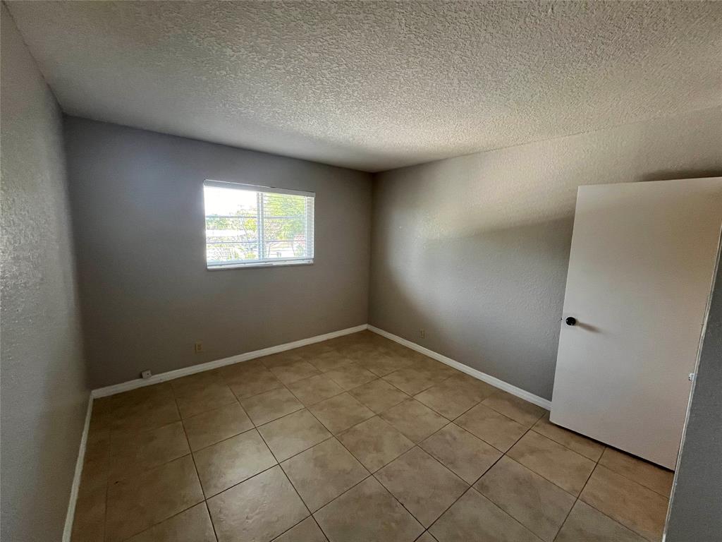2020 Northeast 56th Street, Unit 208 Fort Lauderdale, FL 33308 - Photo 31 of 54 an empty room with windows