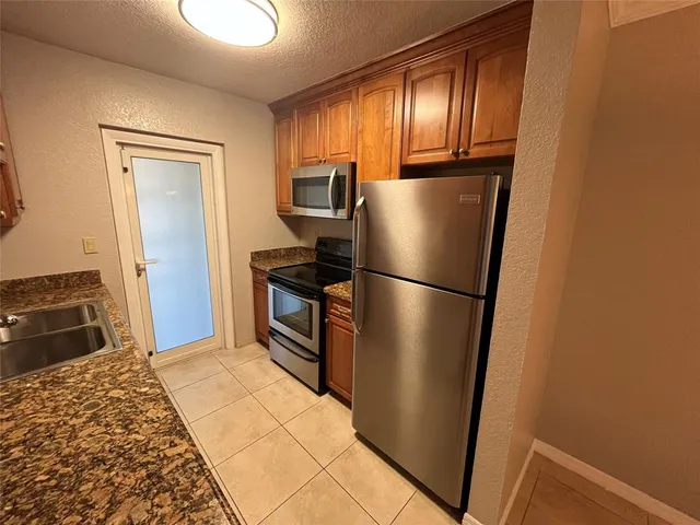 a kitchen with a refrigerator and wooden floor