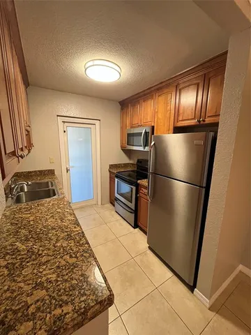 a kitchen with granite countertop a refrigerator and a stove