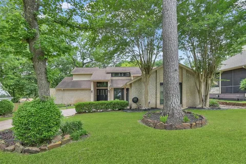 a front view of a house with a yard and trees