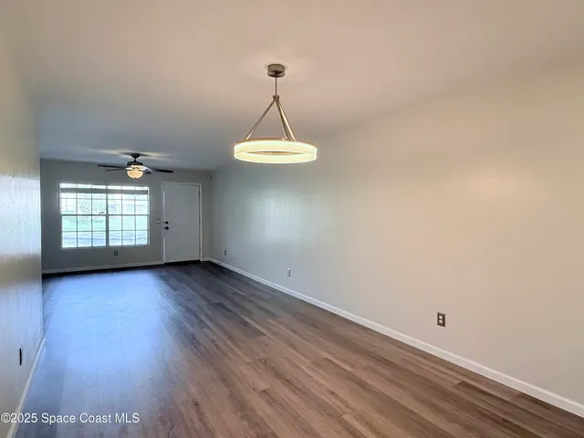 a view of a room with wooden floor and windows