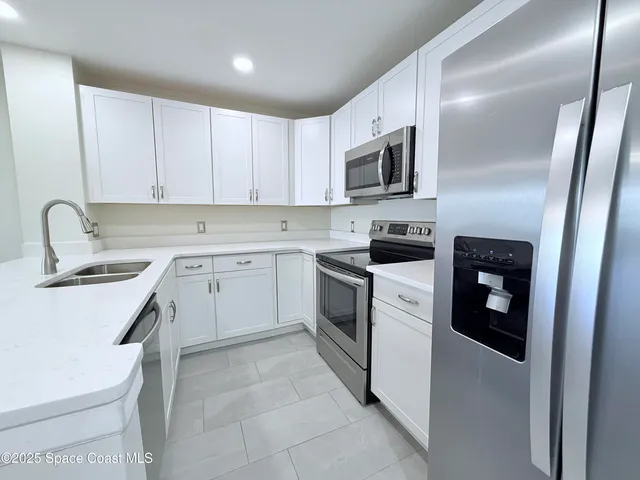 a kitchen with white cabinets and white appliances