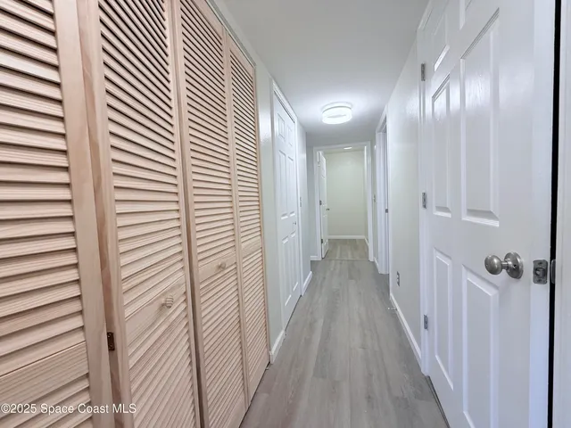 a view of a hallway with wooden floor