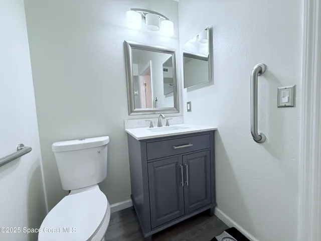a bathroom with a toilet a sink a vanity and mirror