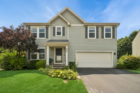 a front view of a house with a garden and yard