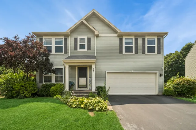 a front view of a house with a garden and yard