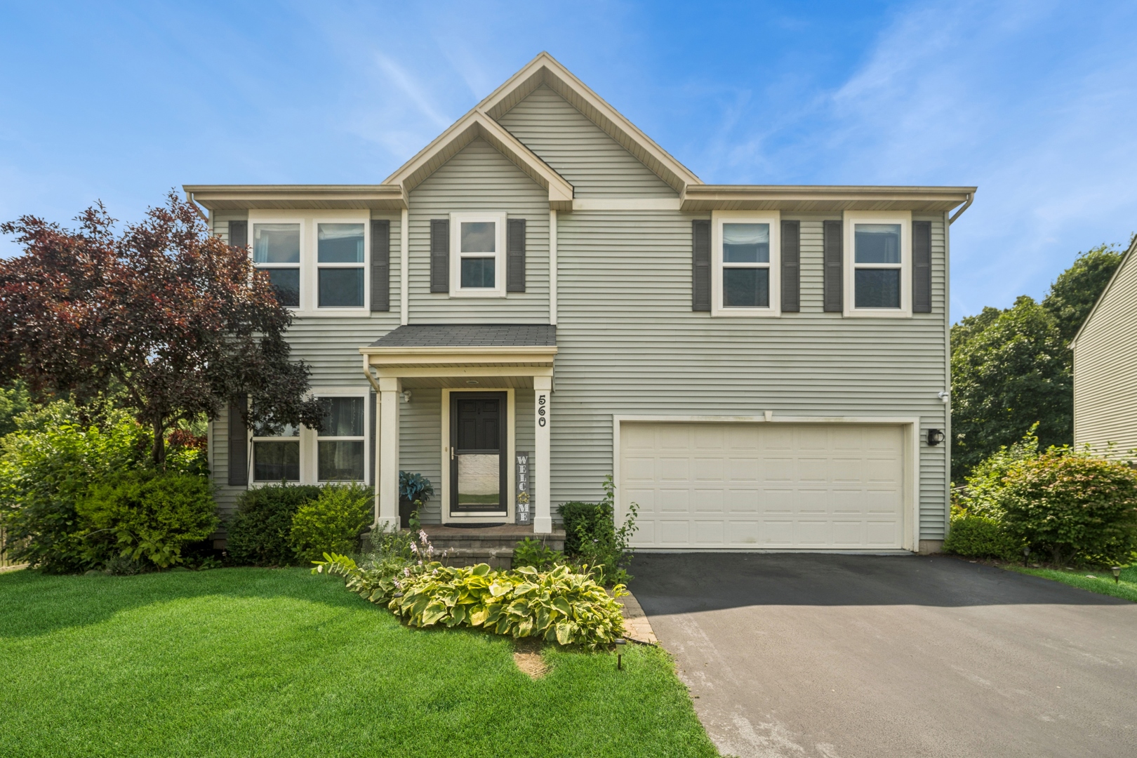 a front view of a house with a garden and yard