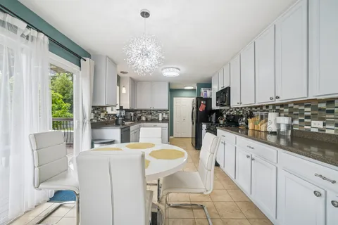 a kitchen with granite countertop white cabinets and stainless steel appliances