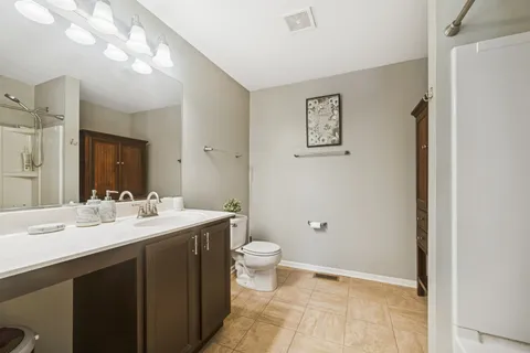 a bathroom with a double vanity sink toilet and a mirror