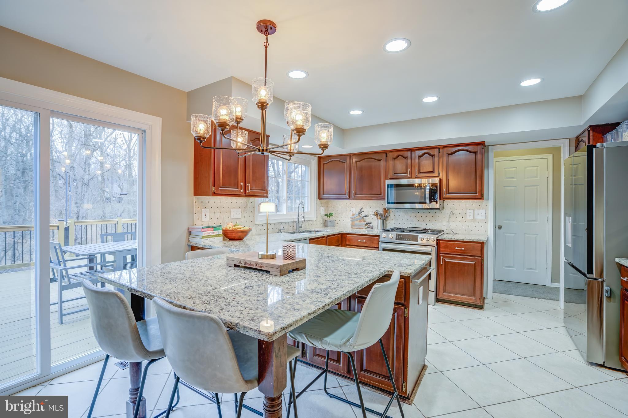 8529 High Timber Court Ellicott City, MD 21043 - Photo 22 of 94 a kitchen with stainless steel appliances granite countertop a stove a refrigerator a kitchen island a table and chairs