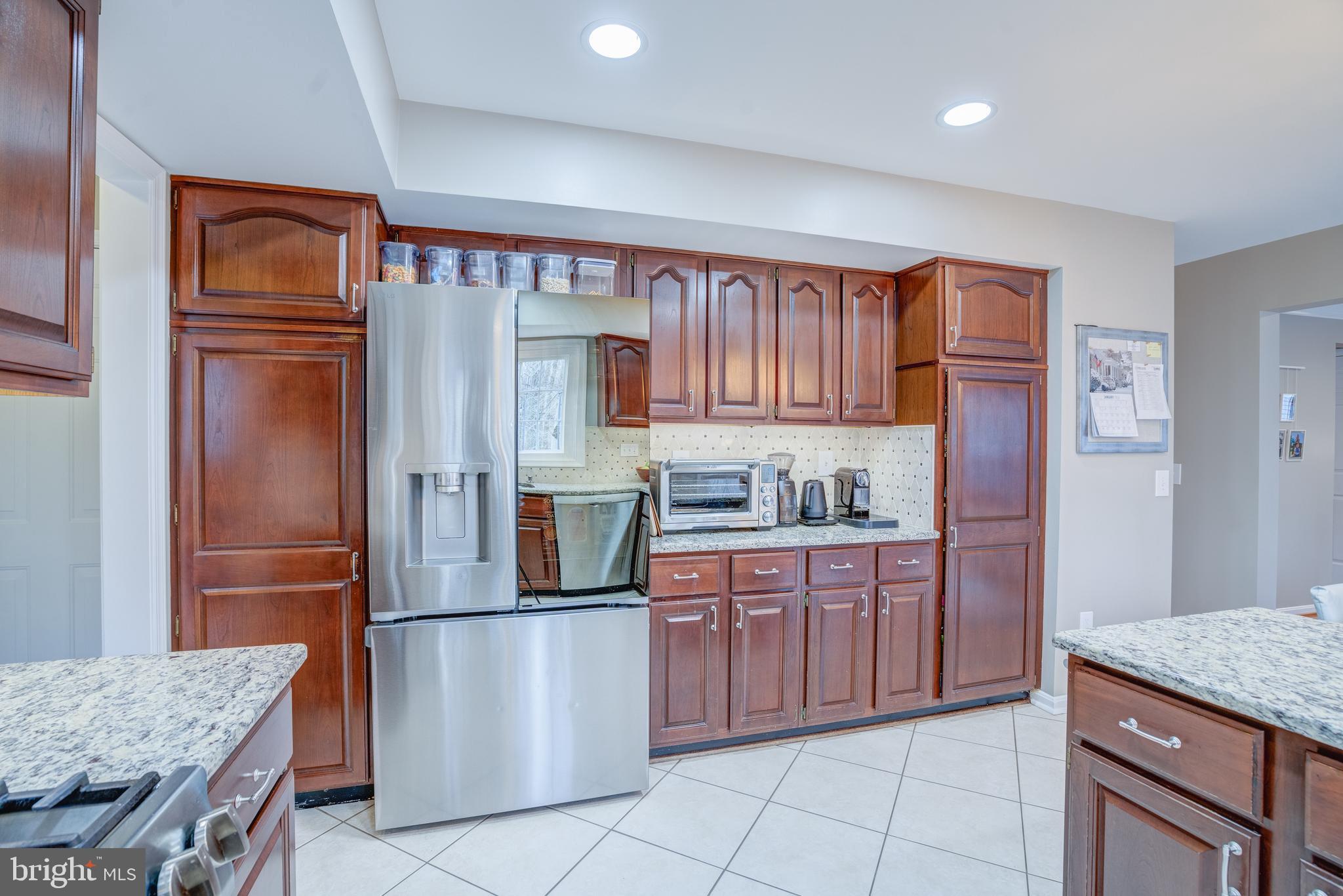 8529 High Timber Court Ellicott City, MD 21043 - Photo 26 of 94 a kitchen with granite countertop a refrigerator and a sink