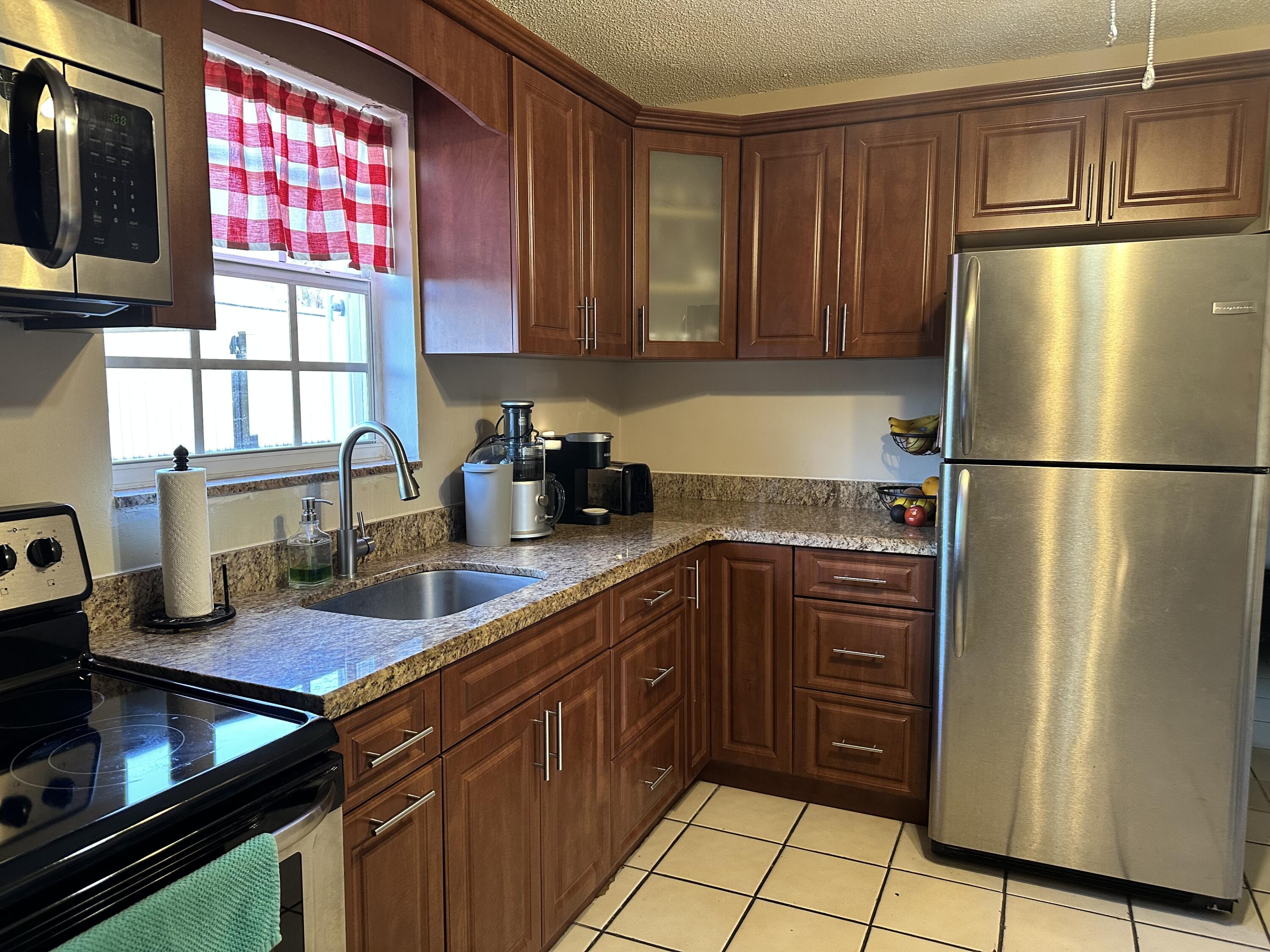 7960 Northwest 174th Street Hialeah, FL 33015 - Photo 14 of 22 a kitchen with stainless steel appliances granite countertop a refrigerator and a sink