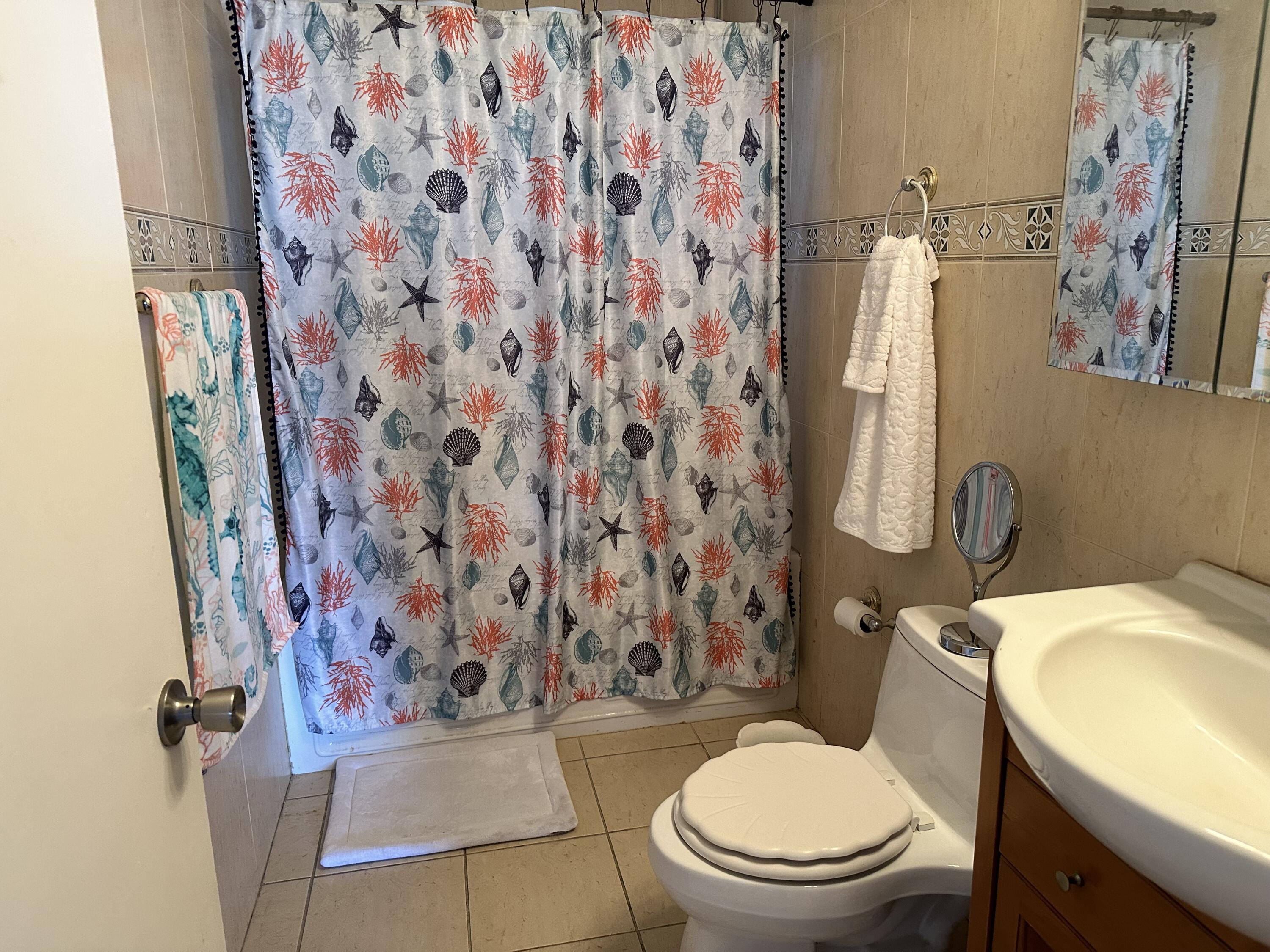 7960 Northwest 174th Street Hialeah, FL 33015 - Photo 20 of 22 a white toilet sitting next to a shower curtain