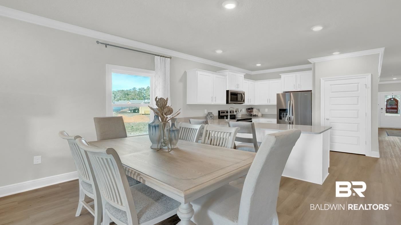 13312 Shea Circle Foley, AL 36535 - Photo 3 of 17 Open-concept interior featuring light wood-finish flooring, white cabinetry, stainless steel appliances, a kitchen island with seating, and recessed lighting