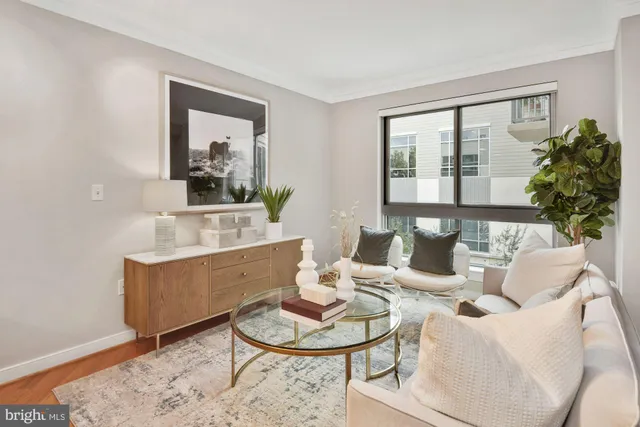 a living room with furniture a lamp paintings and a window