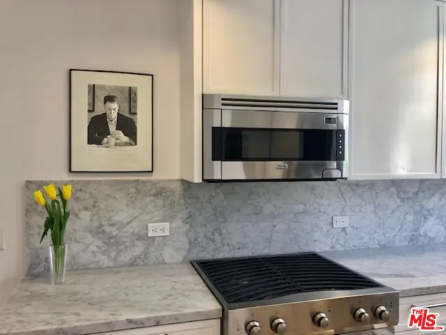 a kitchen with stainless steel appliances granite countertop a sink and a microwave