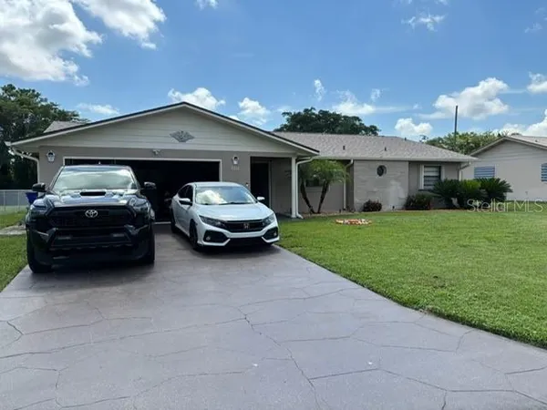 a car parked in front of house with a yard