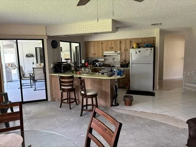 a kitchen with stainless steel appliances kitchen island granite countertop a refrigerator and a stove top oven