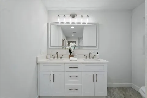 a bathroom with a sink a light fixture and a vanity