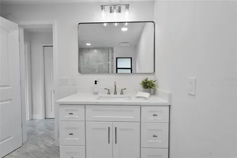 a bathroom with a sink vanity and mirror