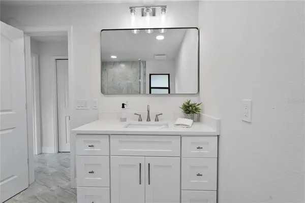 a bathroom with a sink vanity and mirror