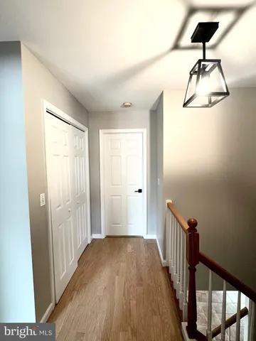 a view of a hallway with wooden floor and staircase