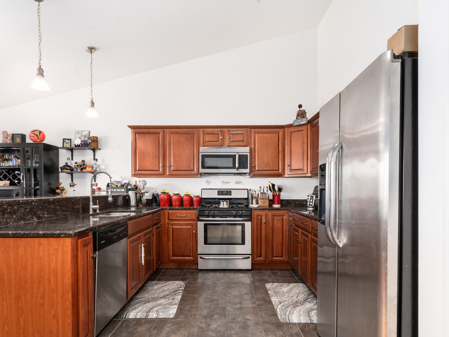 1923 Waters Edge Drive Minooka, IL 60447 - Photo 12 of 24 a kitchen with stainless steel appliances granite countertop a sink a stove and a refrigerator