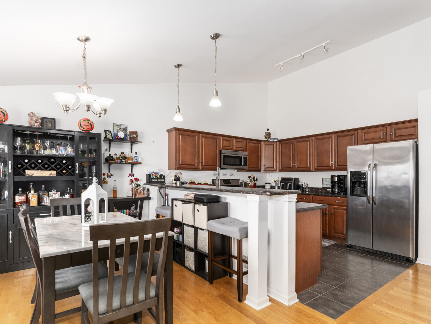1923 Waters Edge Drive Minooka, IL 60447 - Photo 14 of 24 a kitchen with stainless steel appliances kitchen island granite countertop a table chairs and a refrigerator