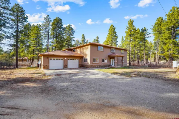 a view of a house with a backyard and tree