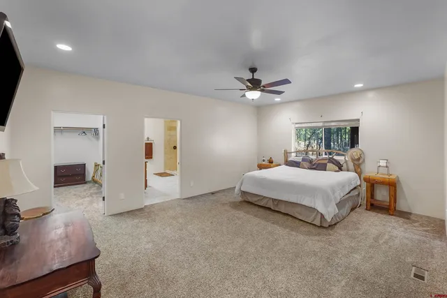 a spacious bedroom with a bed and a chandelier