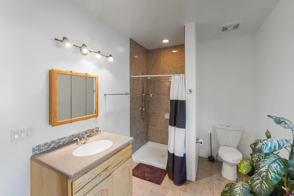 a bathroom with a sink vanity granite and toilet